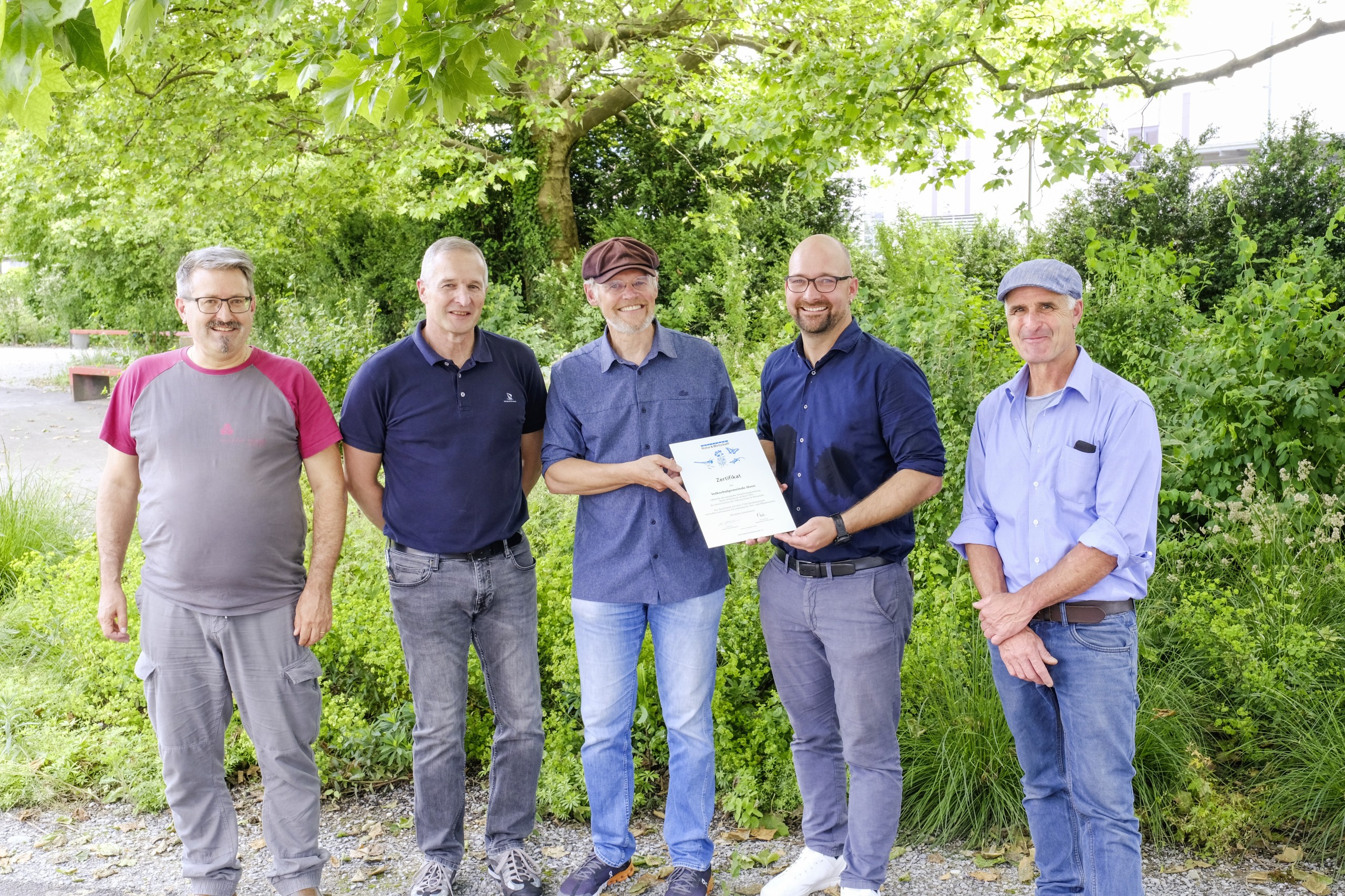 Schulleiter Thomas Mayer (2.v.l.) und Schulpräsident André Mathis (2.v.r.) werden vom Mitgründer der Stiftung Natur und Wirtschaft Reto Locher (3.v.l.) zertifiziert.