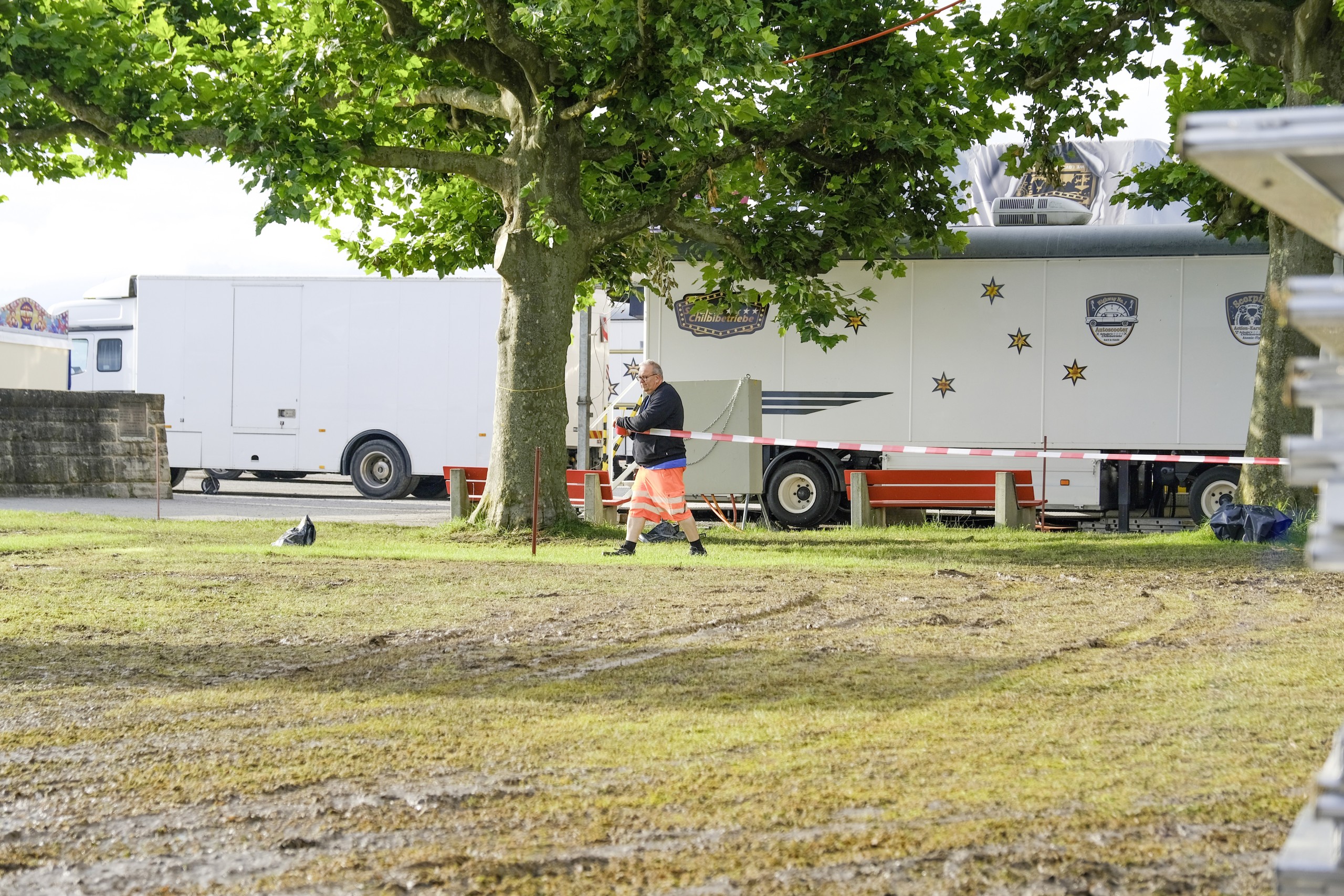 Ein Werkhof-Mitarbeitender sperrt ein Gebiet um eine Baumgruppe ab, damit beim Abbau keine Fahrzeuge über deren Wurzeln fahren und sie beschädigen können.