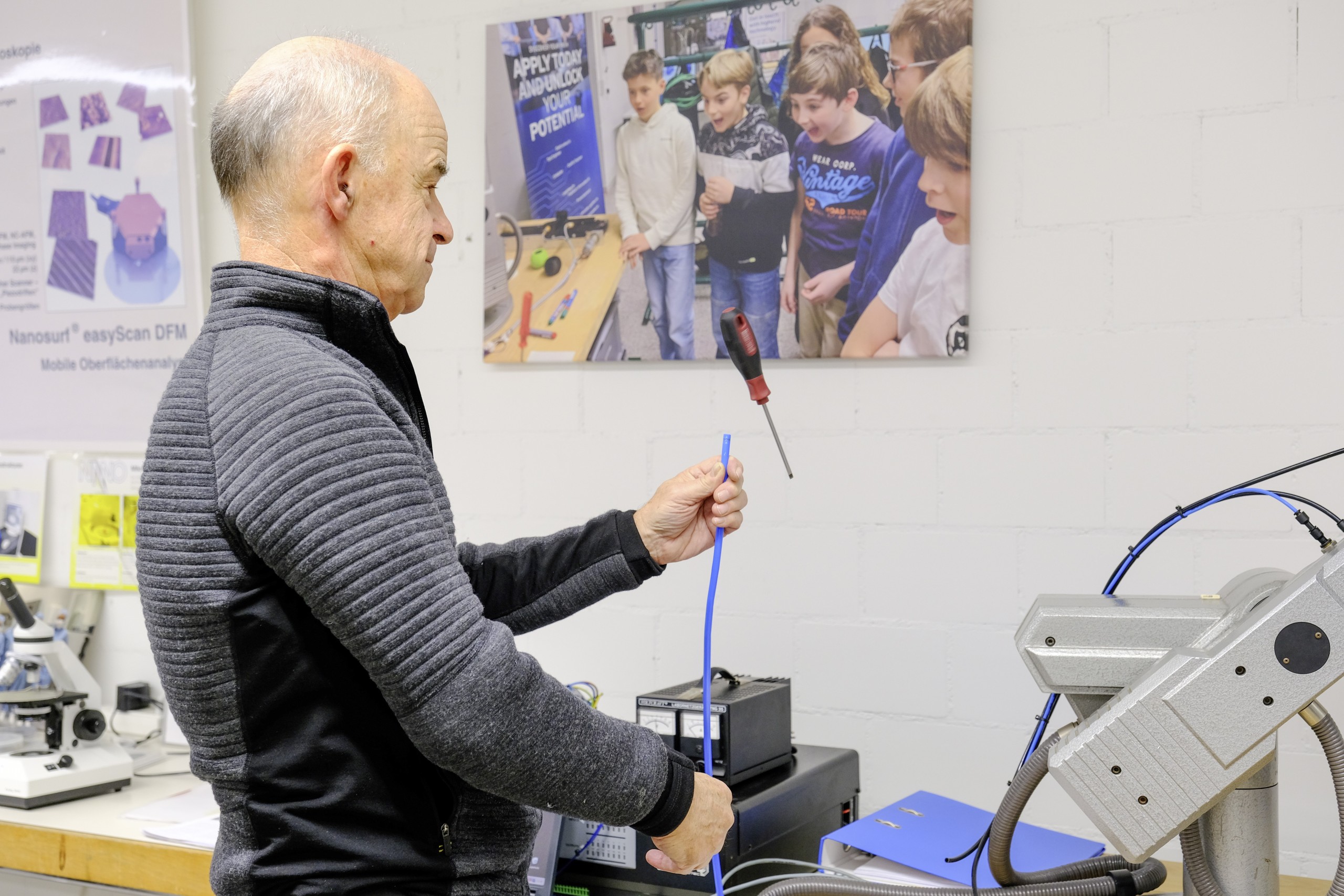 Niklaus Vogel demonstriert den Bernoulli-Effekt. Die Reaktion auf den fliegenden Schraubenzieher war bei der Fotografin etwa dieselbe wie jene der Kinder auf dem Bild an der Wand.