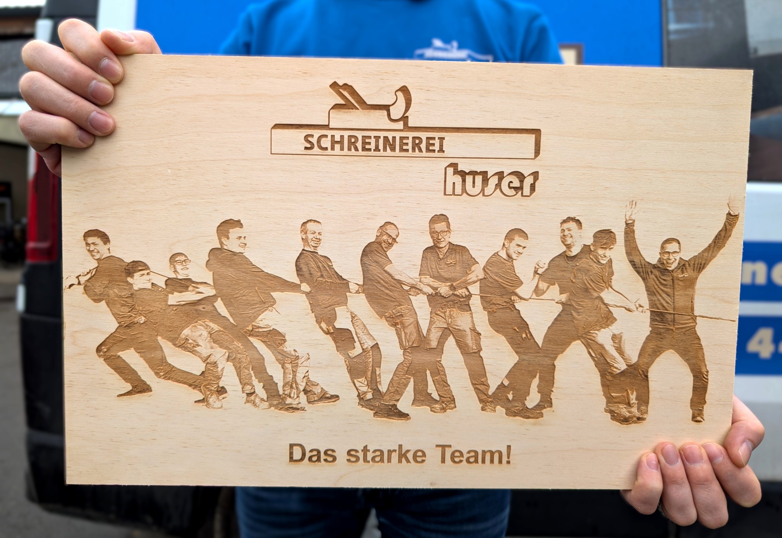 Die Lasergravurmaschine gehört zu den neusten Anschaffungen der Schreinerei Huser in Stein- ach. Mit dem CO2-Laser lassen sich verschiedenste Materialien wie Holz, Schiefer oder Glas mit Schriftzügen und Bildern personalisieren, wie beispielsweise hier das Teambild von Manuel Popp (links) und seinen Mitarbeitern.