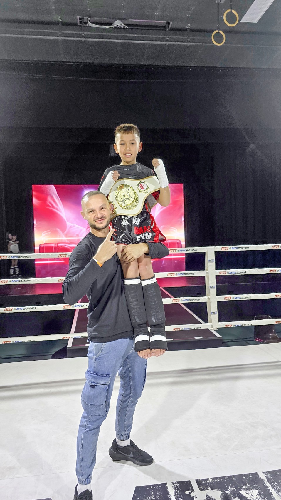 Der neue Schweizermeister im Kickboxen, Liam Alder, feiert auf den Schultern seines Trainers Mirhad Babic seinen Titel.