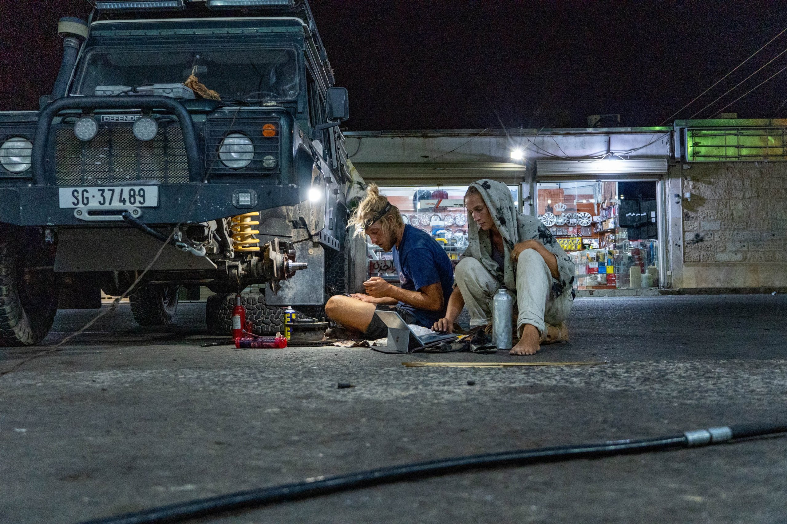 Martina und Tobias Baumeler reparieren ihren Defender «Olga» auf einem Parkplatz in Saudi-Arabien.
